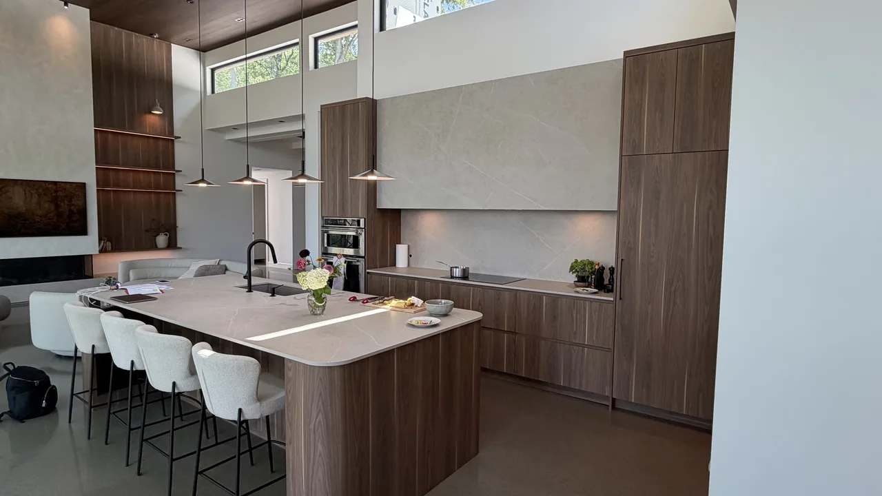 Cuisine à aire ouverte avec grand îlot en noyer et plafond en bois massif à double hauteur