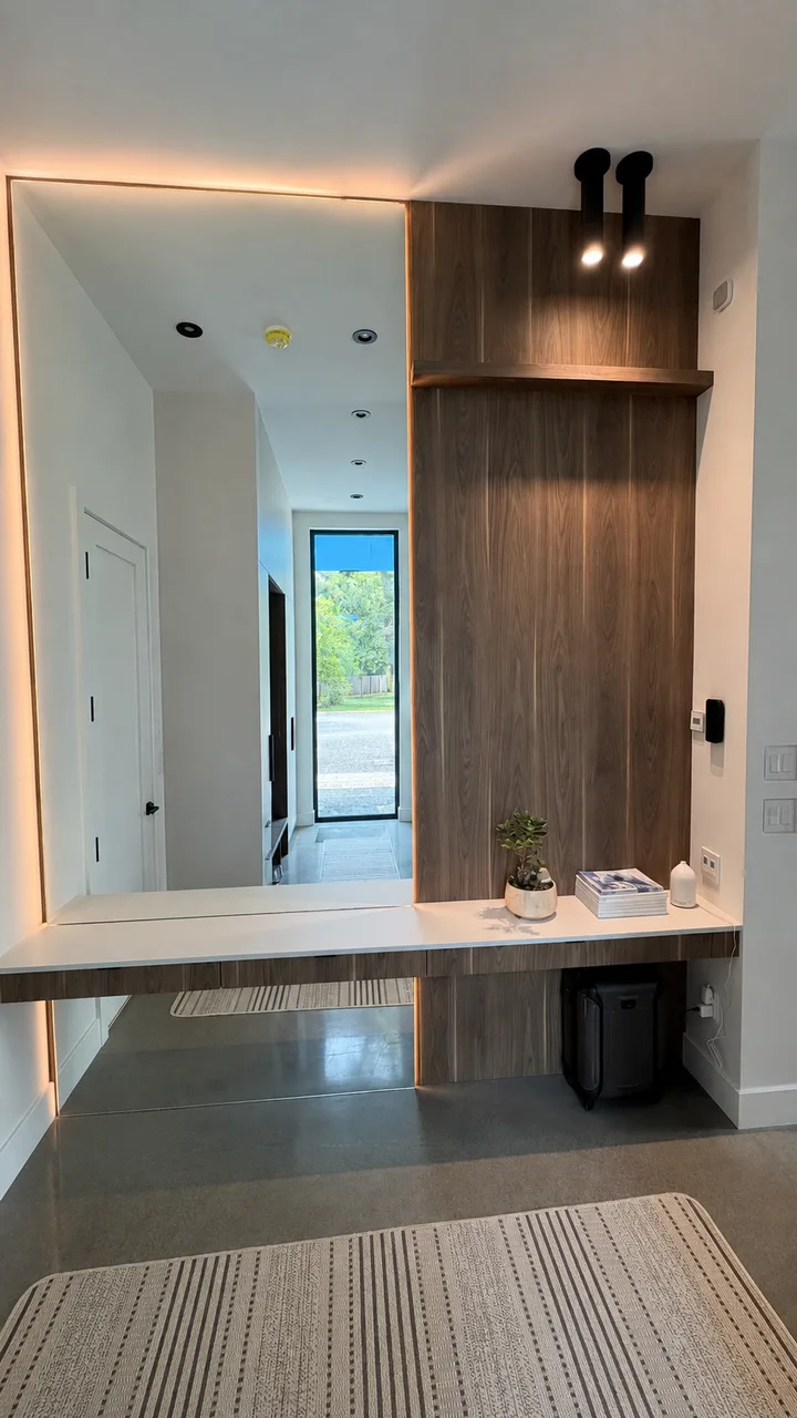 Entrée avec banc-console en noyer et miroir pleine hauteur éclairé