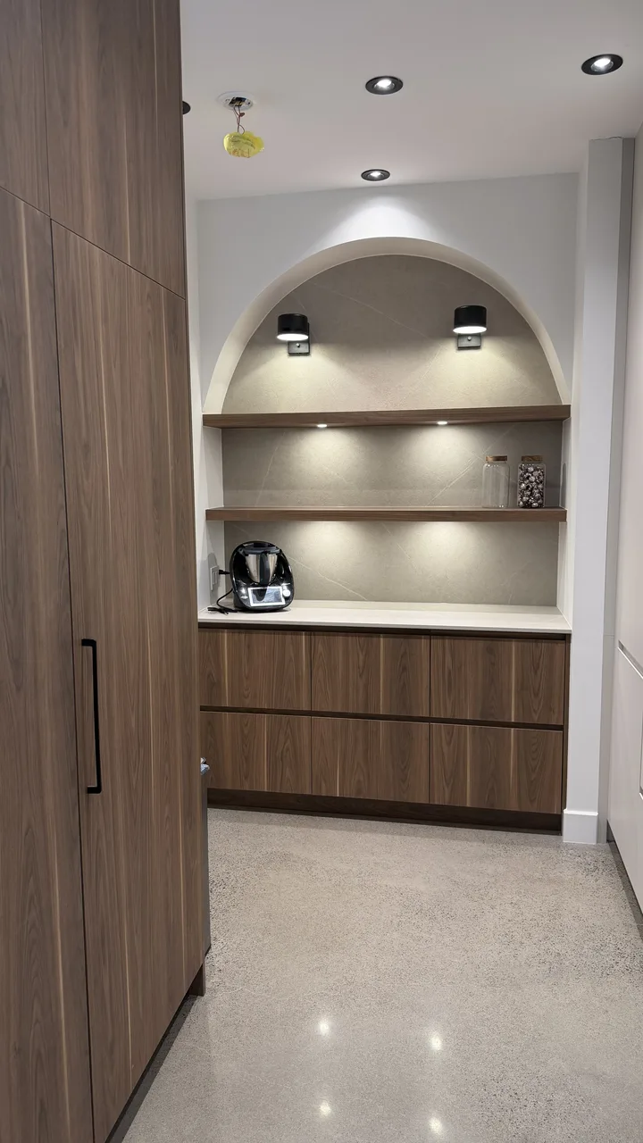 Garde-manger avec niche cintrée en Dekton et éclairage encastré sous les tablettes