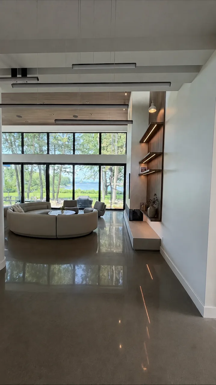 Grande pièce de vie avec mur de rangement en noyer et tablettes éclairées