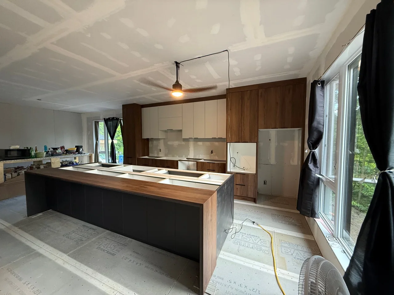 Cuisine sur mesure noire et noyer pendant les travaux