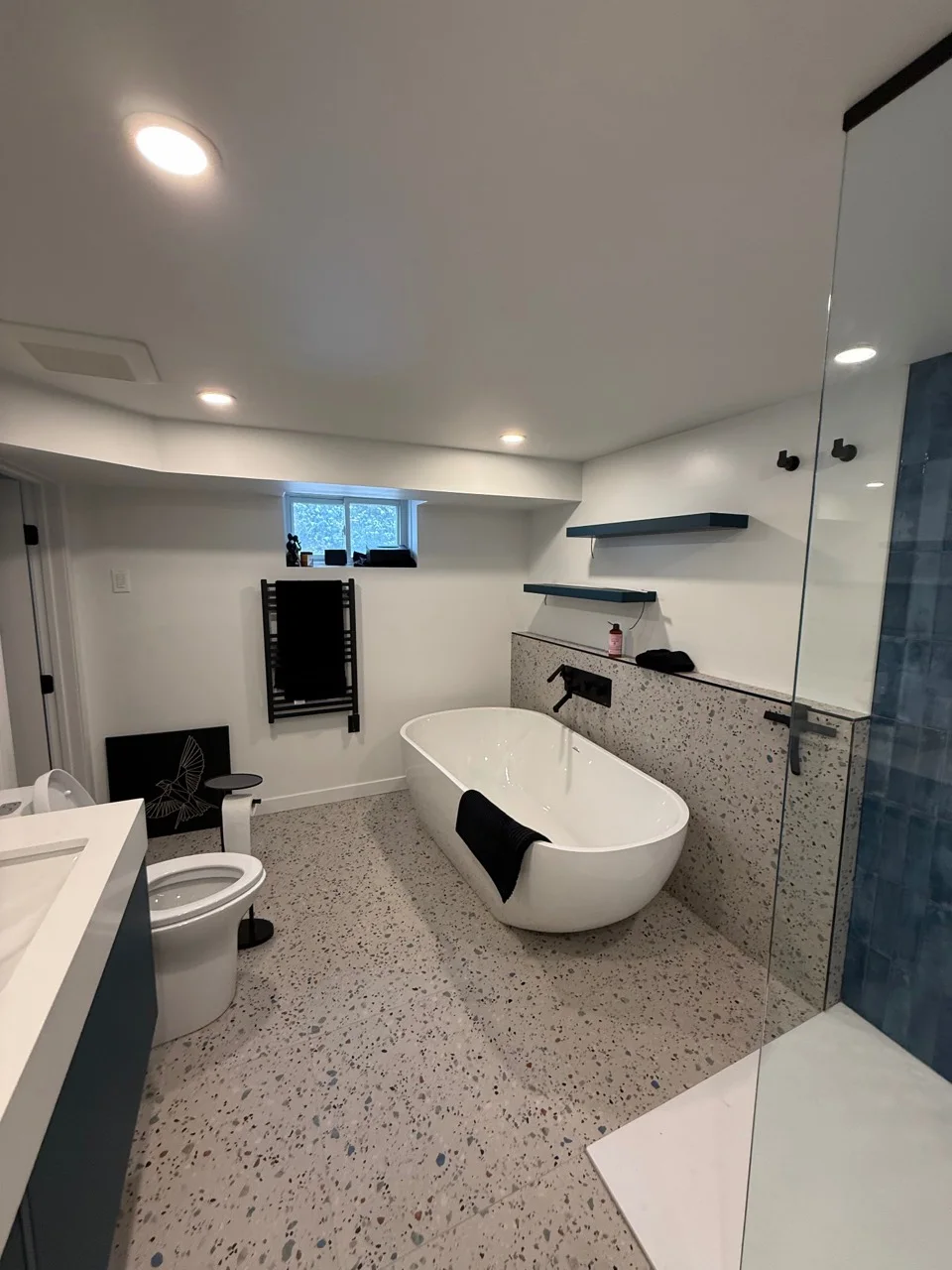 Salle de bain avec bain autoportant, terrazzo et douche bleu profond