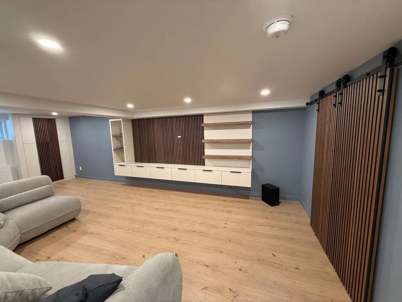 Mur de rangement intégré et lattes de bois dans un salon