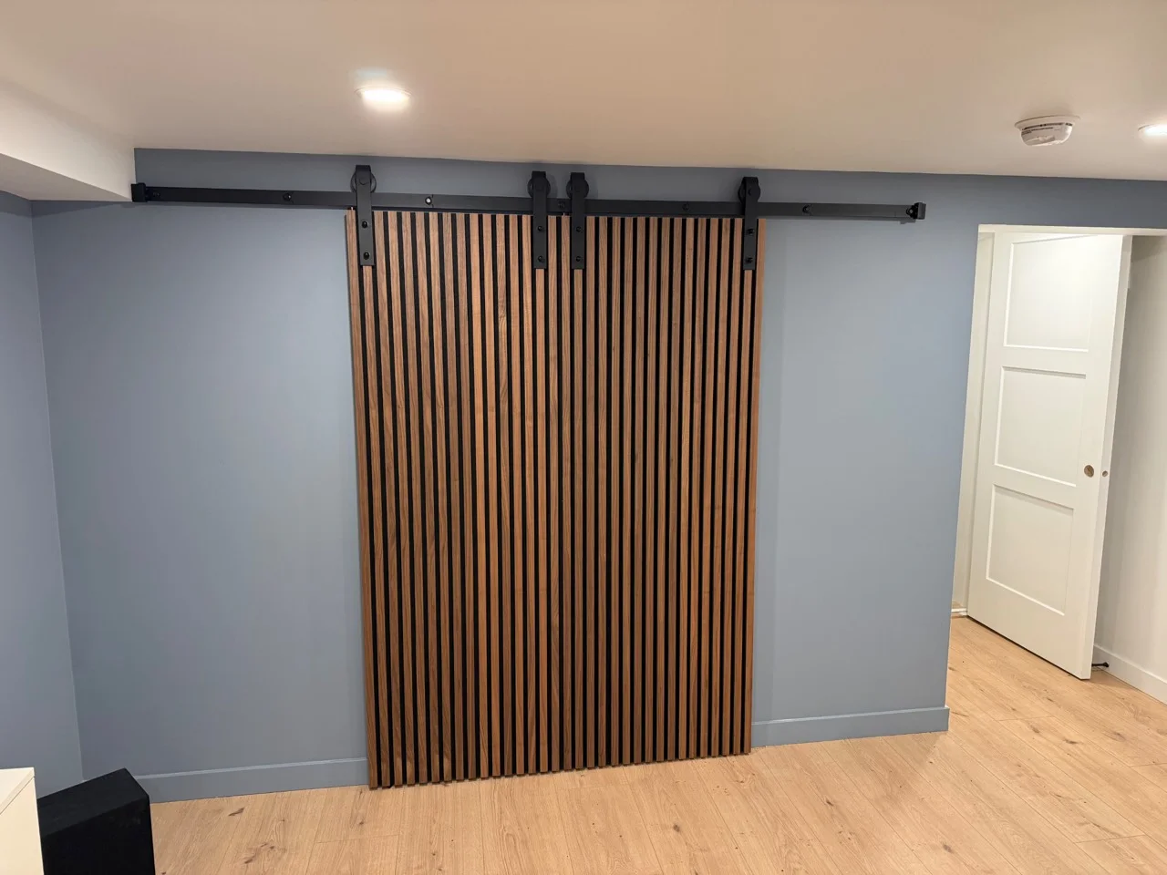Porte coulissante en lattes de bois sur mesure